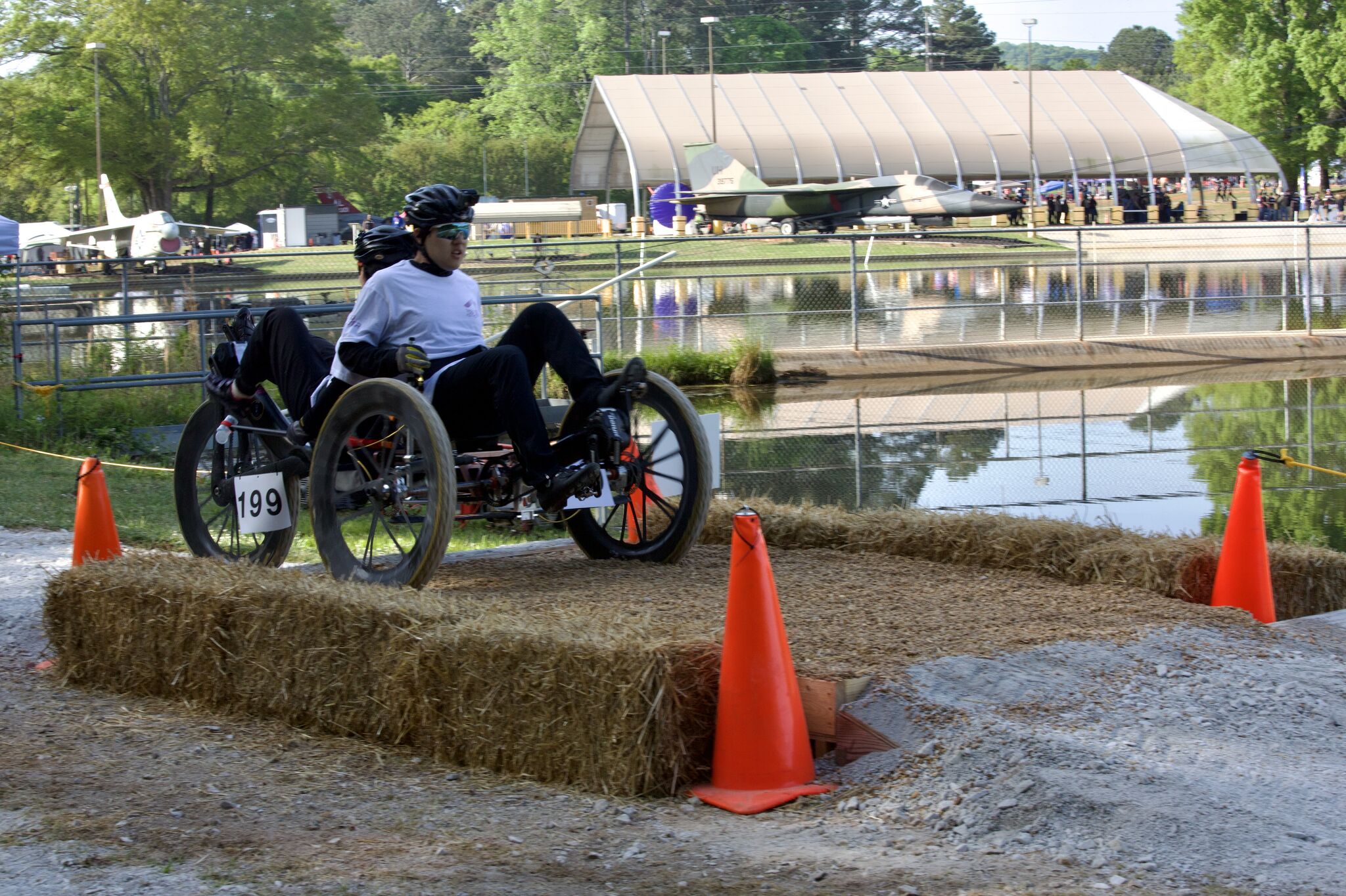 Two RISD Rover Team riders steering the rover over a hay-bale obstacle on the NASA HERC course